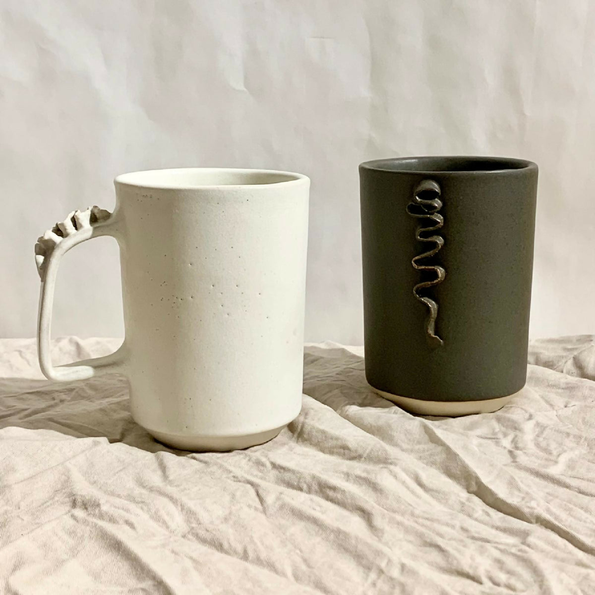 Tasses à thé en céramique blanche et kaki foncé, anse sculptée.