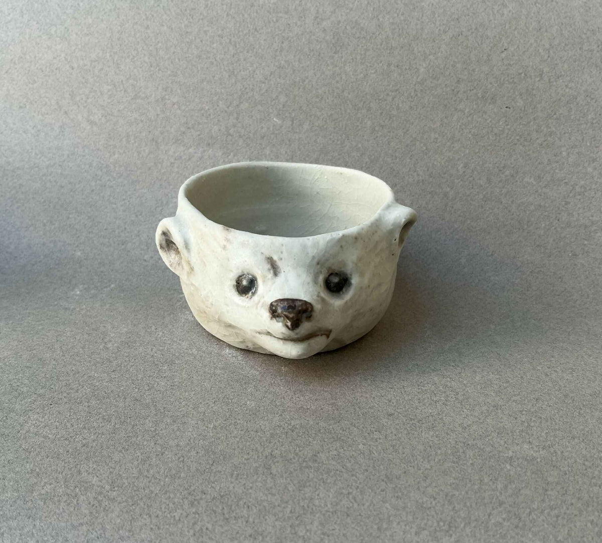 Bol en céramique en forme de visage d’ours, blanc cassé, bords arrondis, motifs noirs