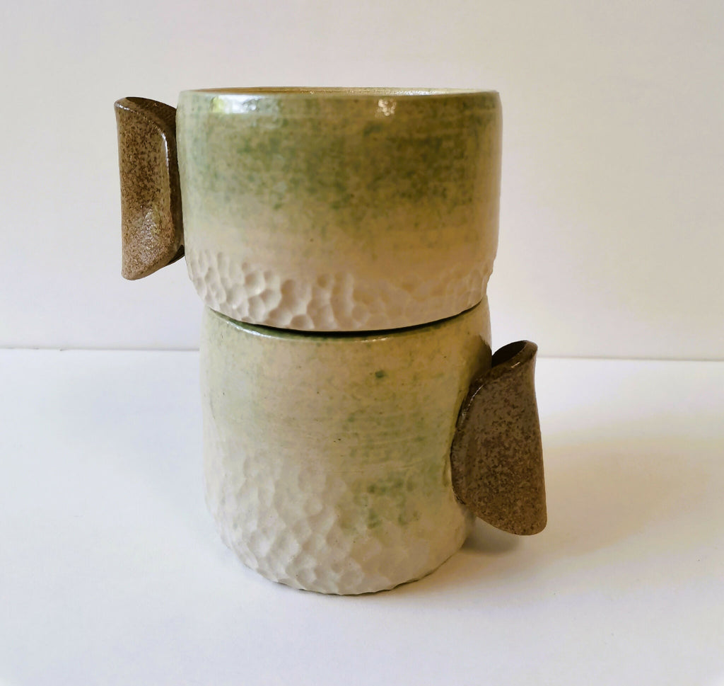 Deux tasses en céramique texture grés et manches couleur brun, empilées