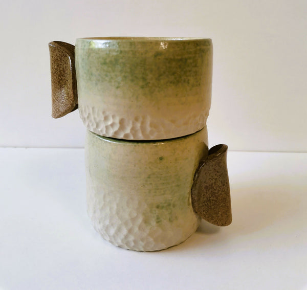 Deux tasses en céramique texture grés et manches couleur brun, empilées