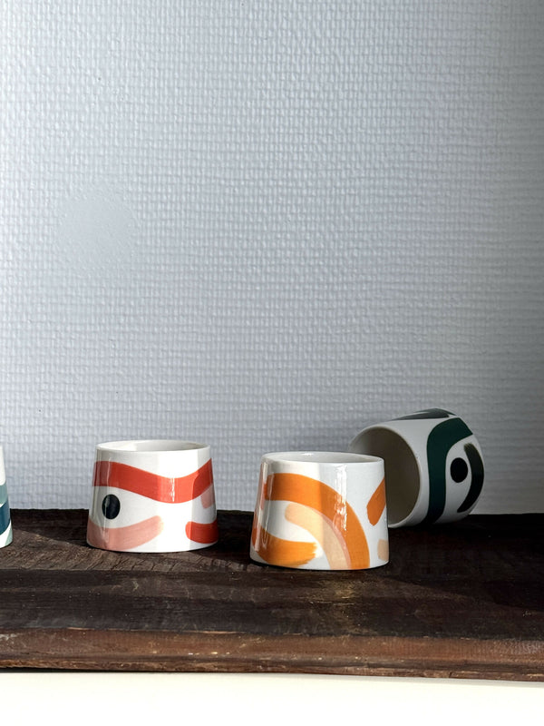 Petites tasses trapèze en céramique, motifs abstraits orange et crème, anse.