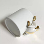 Tasse en céramique blanche, vue de biais avec décoration grenouille dorée
