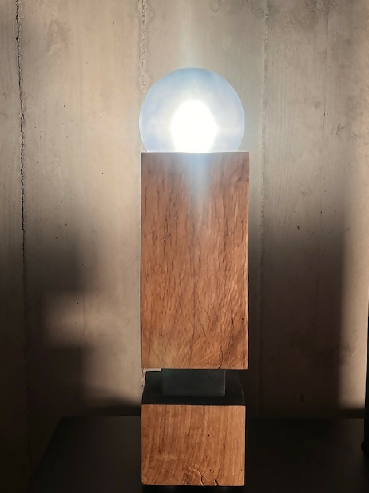 Sculpture lumineuse en bois avec globe lumineux arrondi, base rectangulaire