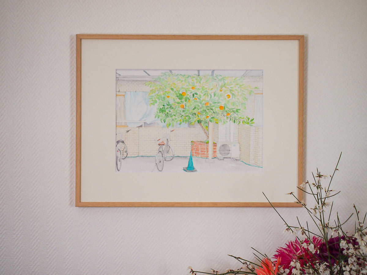 Affiche d’art encadrée avec patio, arbre vert aux oranges et vélo, style aquarelle.