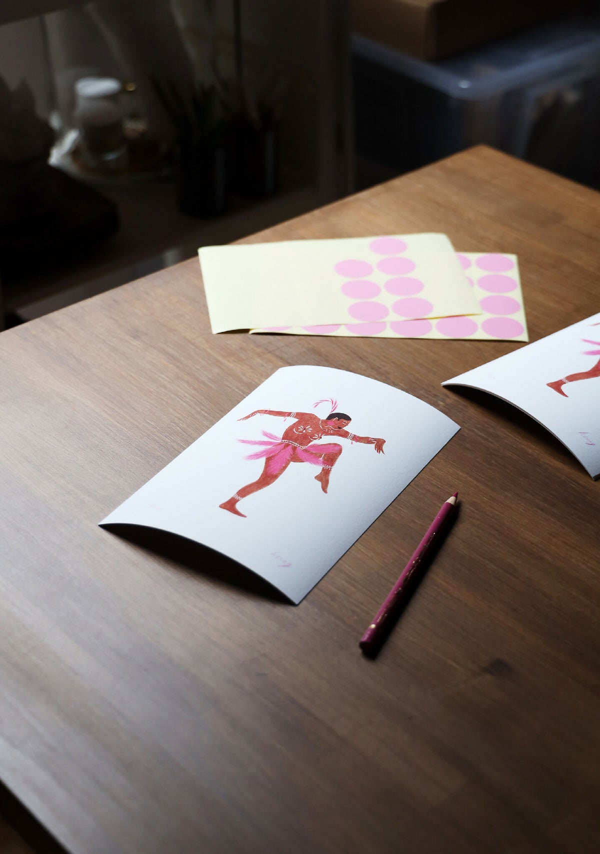 Tirage d’art Joséphine sur table : carte blanche avec ballerine rose et rouge, stylo.