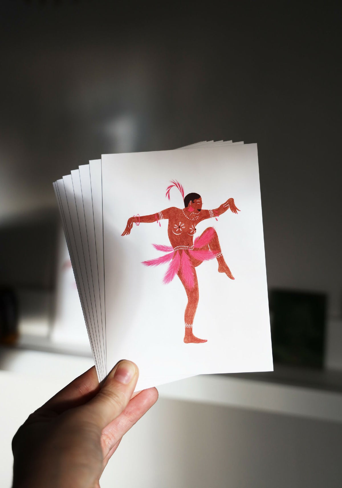 Tirage d’art Joséphine tenu en main : carte blanche avec ballerine rose et rouge.