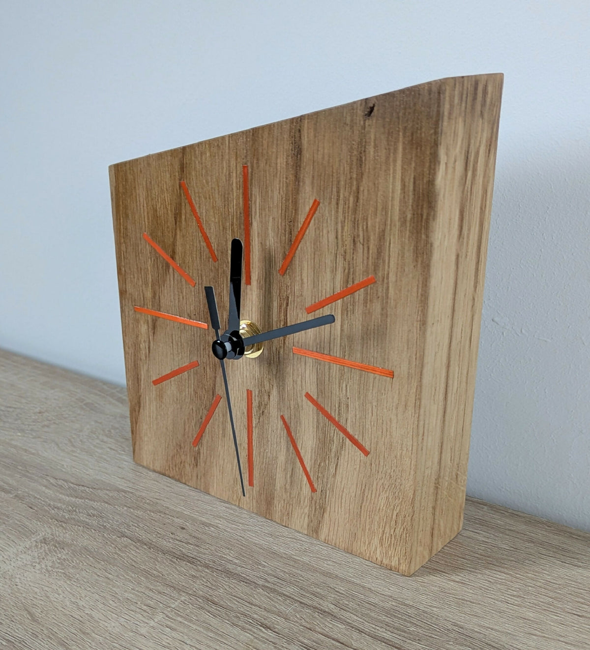 Horloge de bureau en chêne, cadran avec repères rouges, aiguilles noires, vue en biais