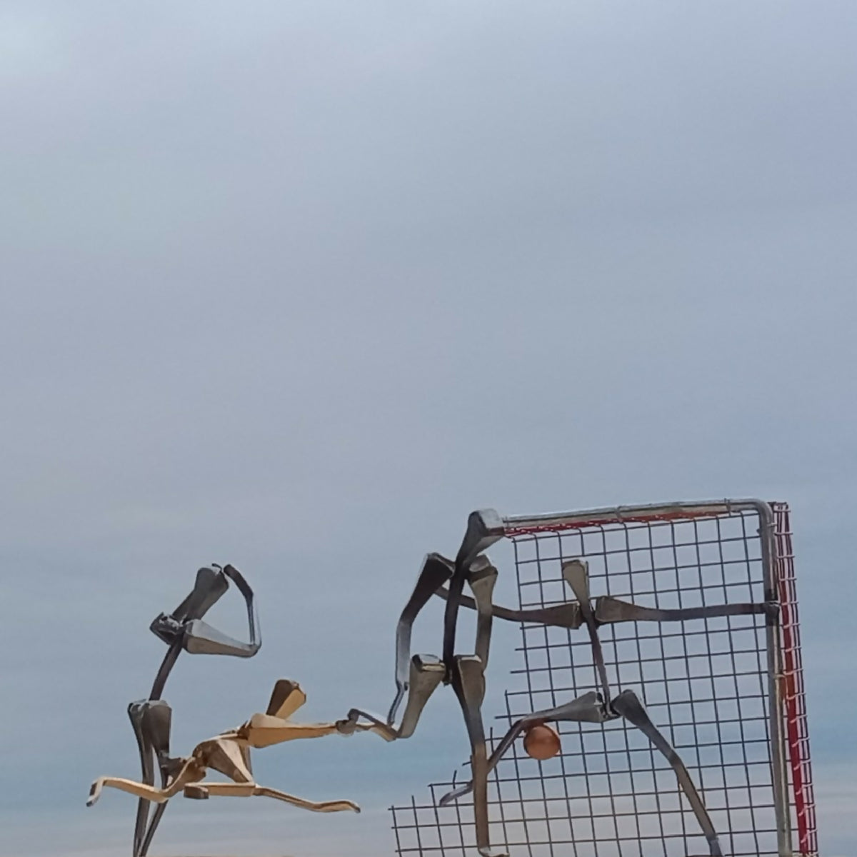 But de handball en métal rouge, figurine de joueur à gauche et cadre grillagé