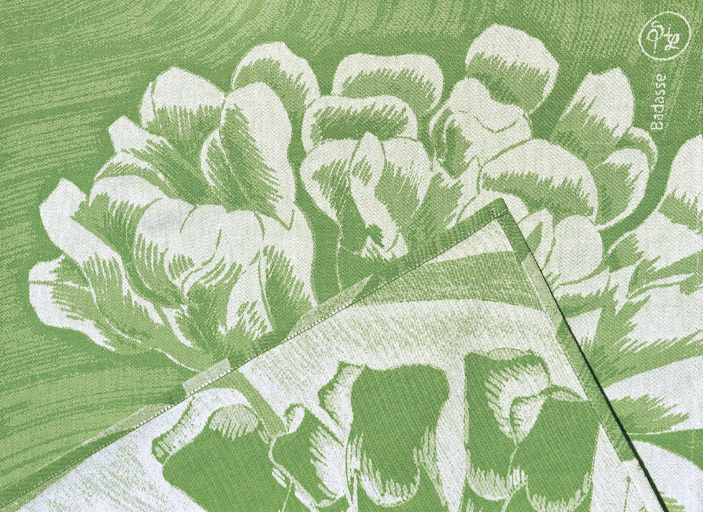 Détail du torchon : motif floral blanc sur fond vert, texture tissée