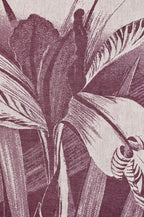 Torchon imprimé, gros plan : feuilles et plumes violet sur fond clair.