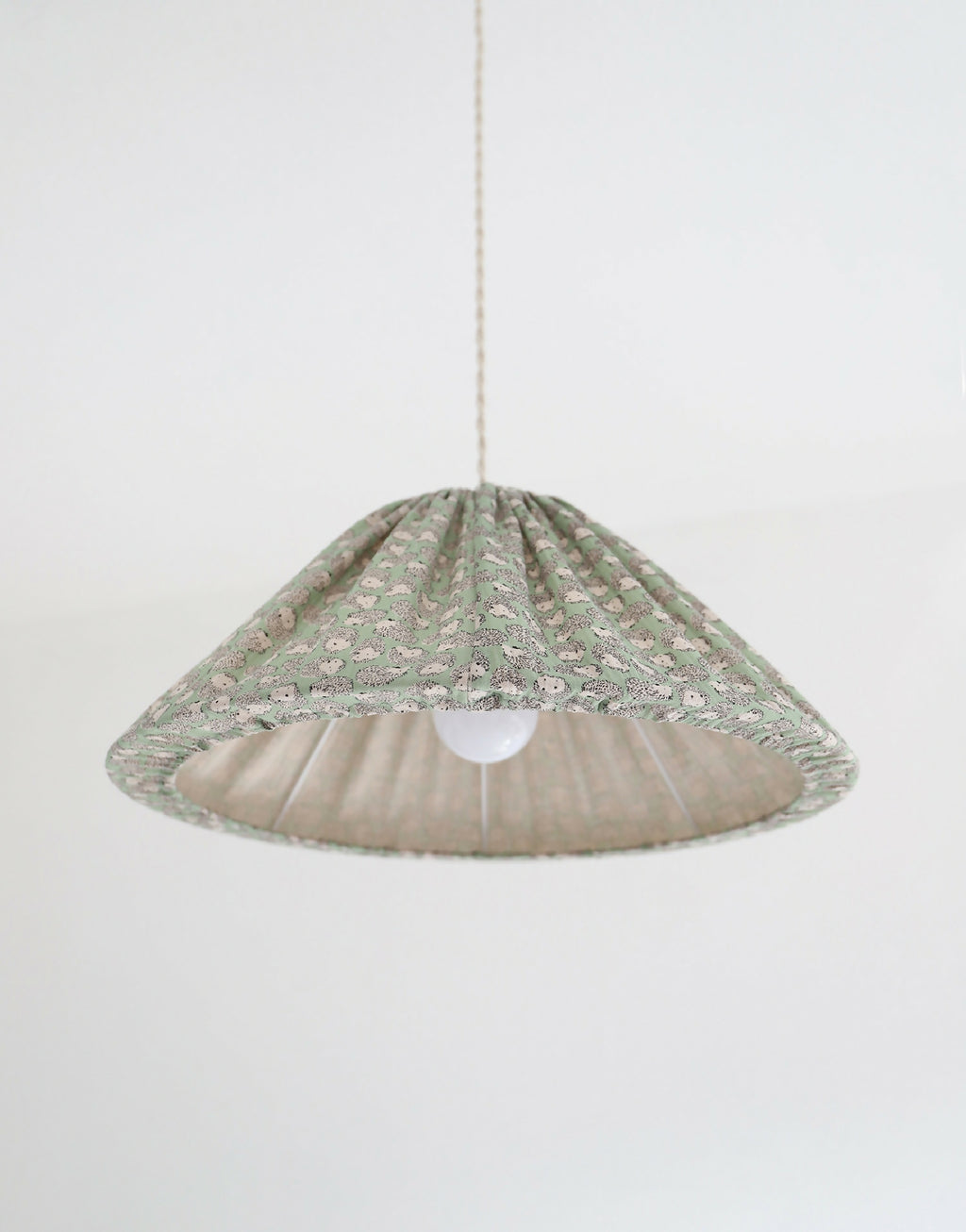 Suspension conique à motif hérissons verts, vue de dessous avec lumière allumée