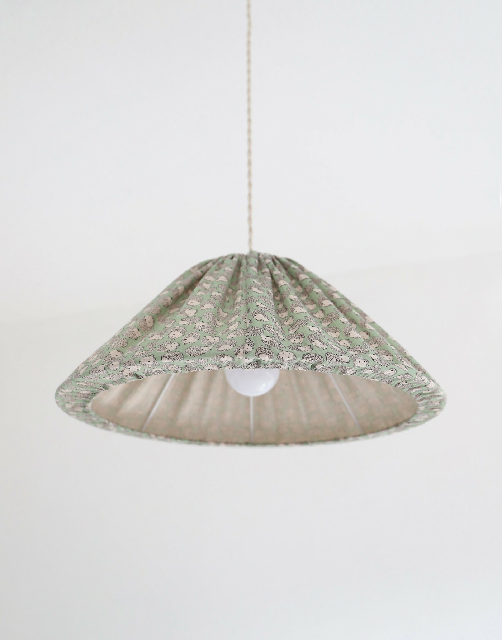 Suspension conique à motif hérissons verts, vue de dessous avec lumière allumée