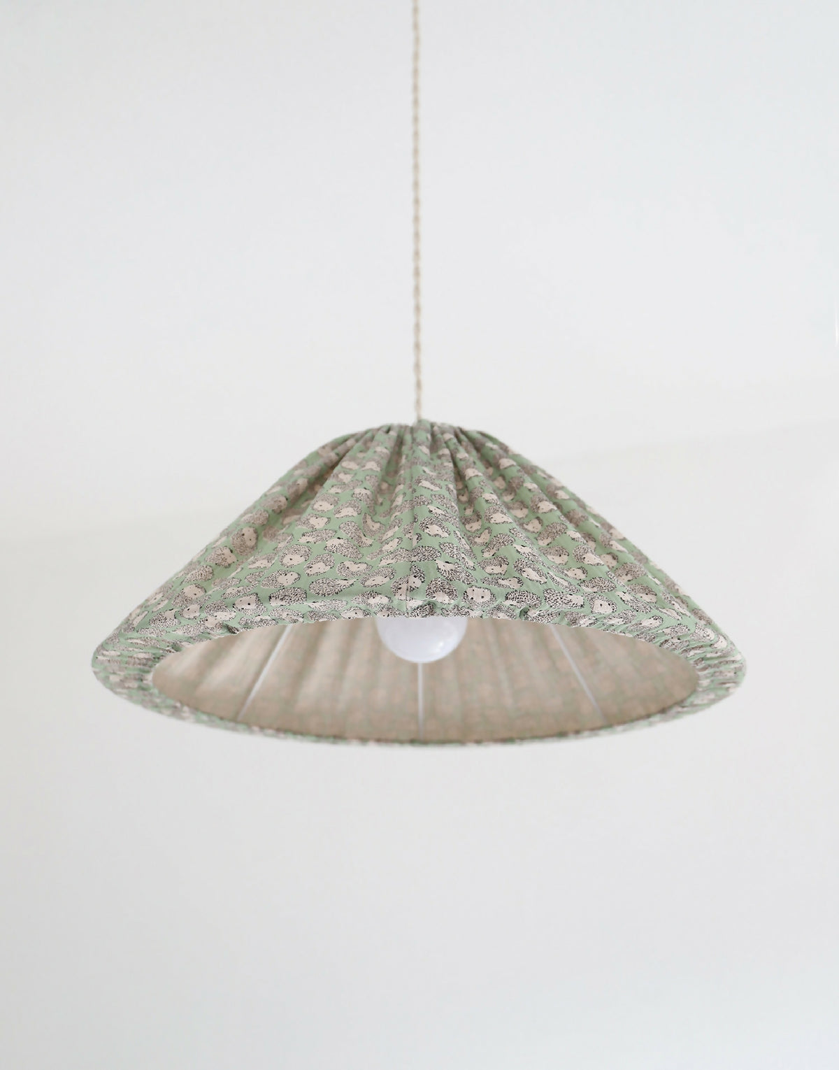 Suspension conique à motif hérissons verts, vue de dessous avec lumière allumée