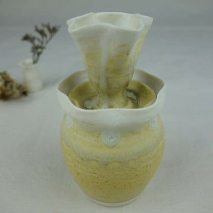 Vase en céramique jaune pâle, vue en léger plongé, bord blanc ondulé et intérieur vert