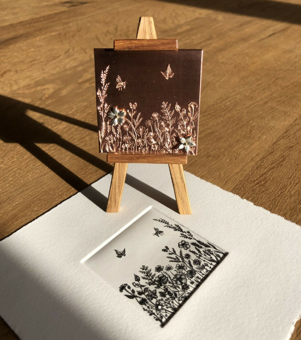 Tableau fleuri à cadre foncé, fleurs dorées et papillons, avec carte assortie