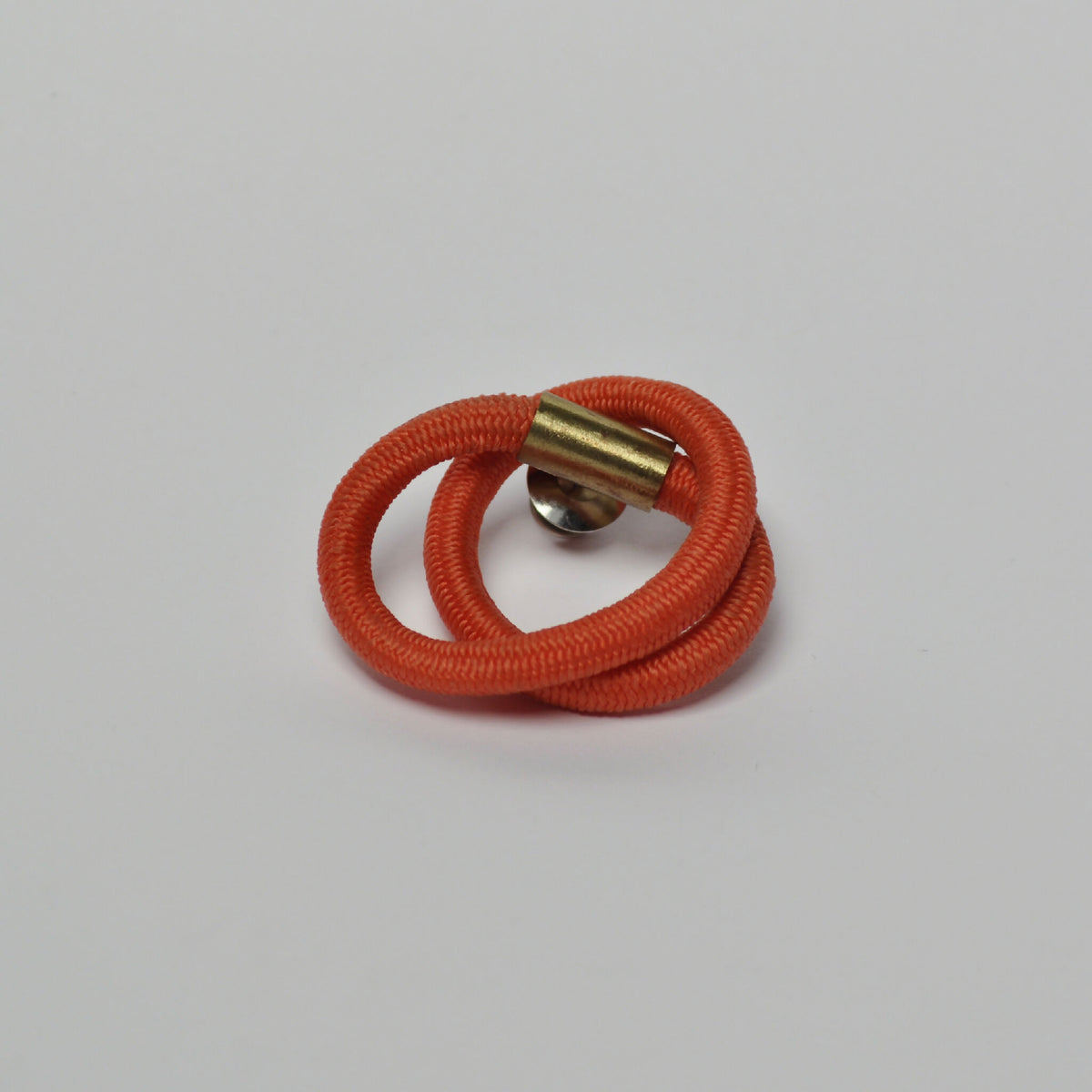 Broche entrelacs cordon orange, fermoir doré avec intérieur visible