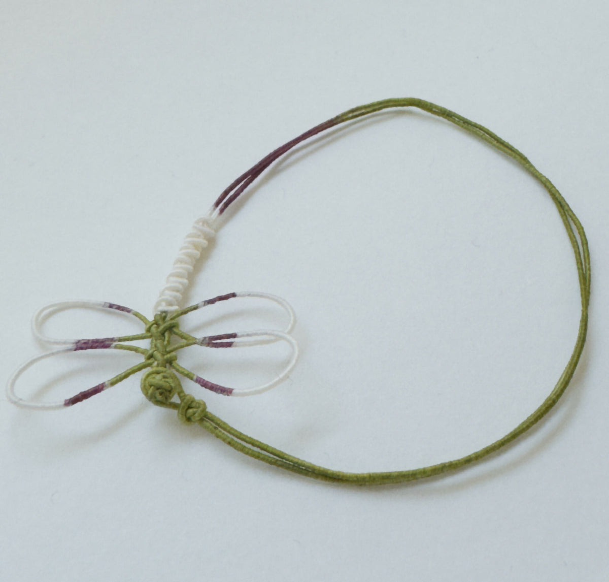 Bracelet élastique vert avec nœud central et motif libellule peinte à rayures