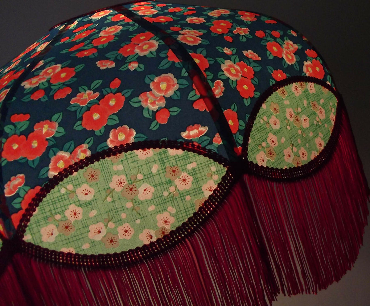 Abat-jour rétro papier japonais vue de côté, franges bordeaux et motifs fleuris.