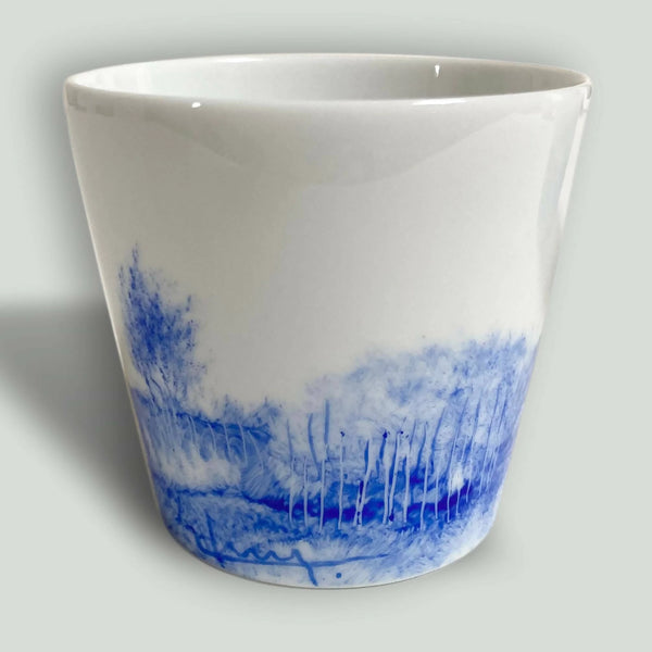 Tasse en porcelaine blanche avec motif paysage bleu sur la paroi