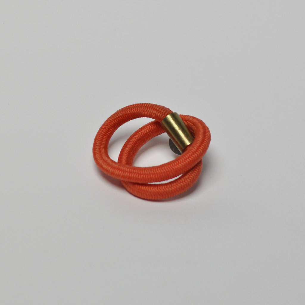 Broche entrelacs avec cordon orange et fermoir doré en forme de boucle