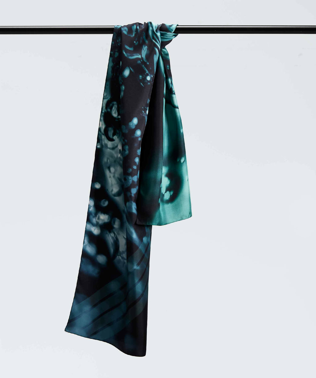 Écharpe en satin turquoise à motif abstrait, drapée sur une barre