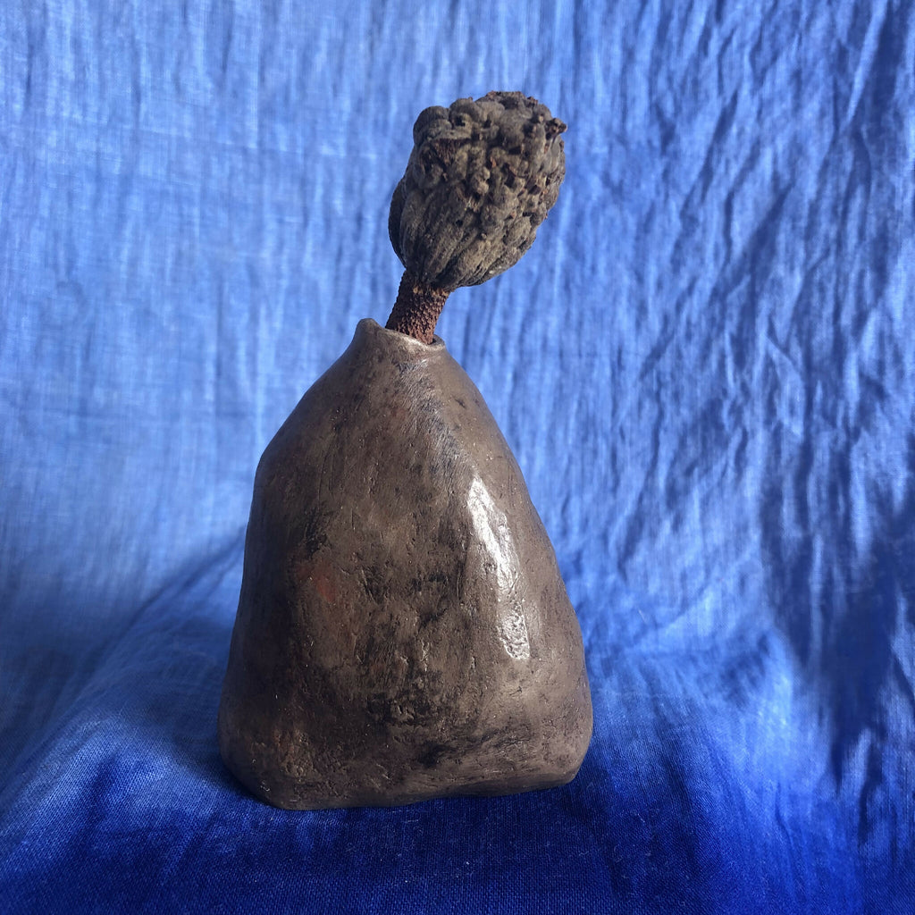 Vase à herbes sèches en céramique sombre, vue trois-quarts avec tige décorée