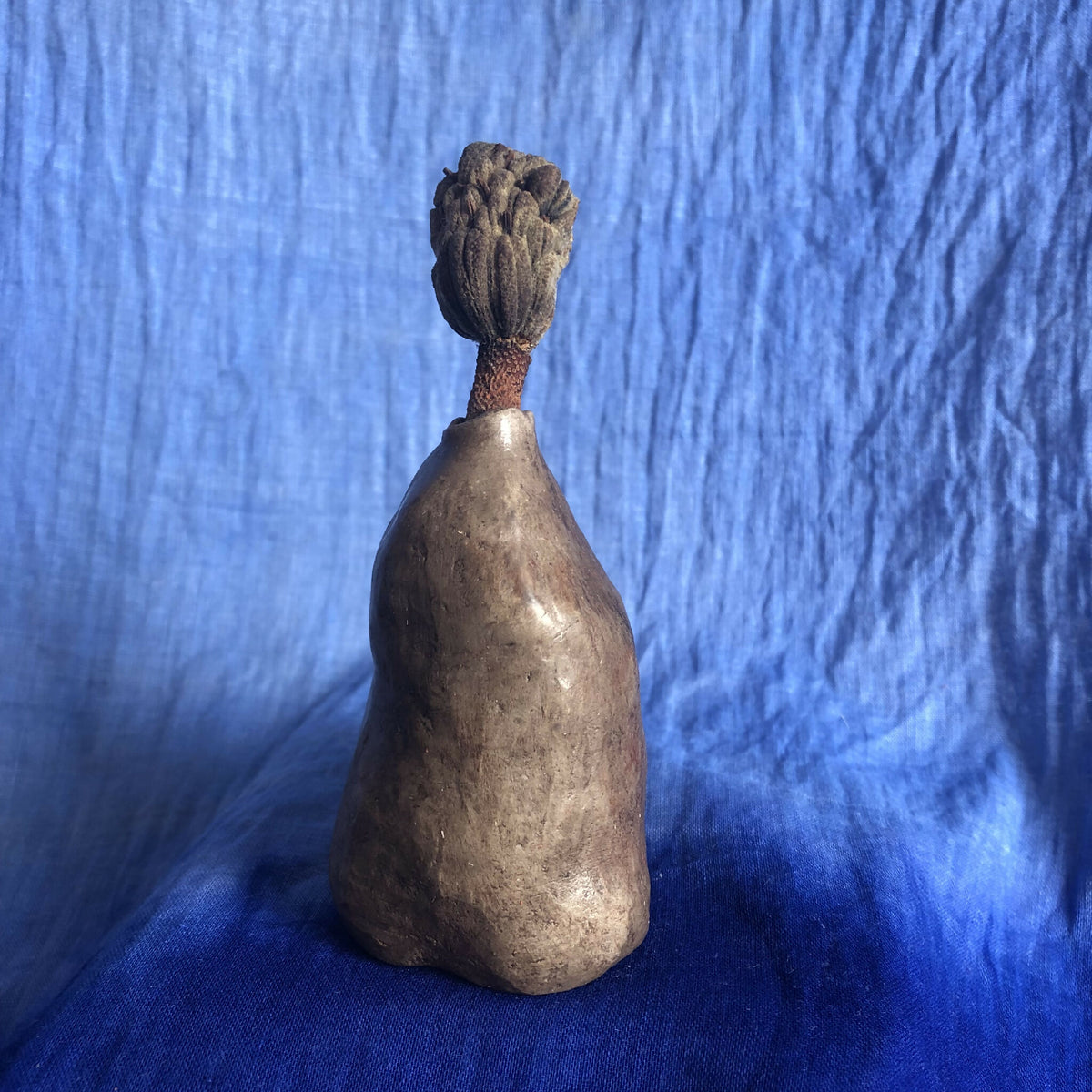 Vase à herbes sèches en céramique sombre, vue de face avec tige texturée sur le dessus