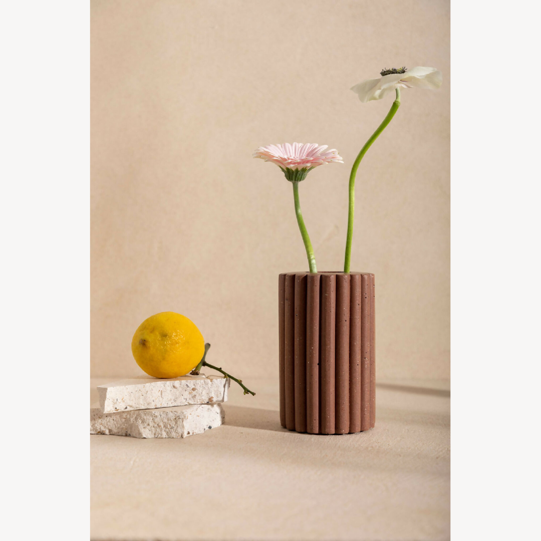 Vase en céramique beige striée, avec fleurs roses et violettes en bouquet.
