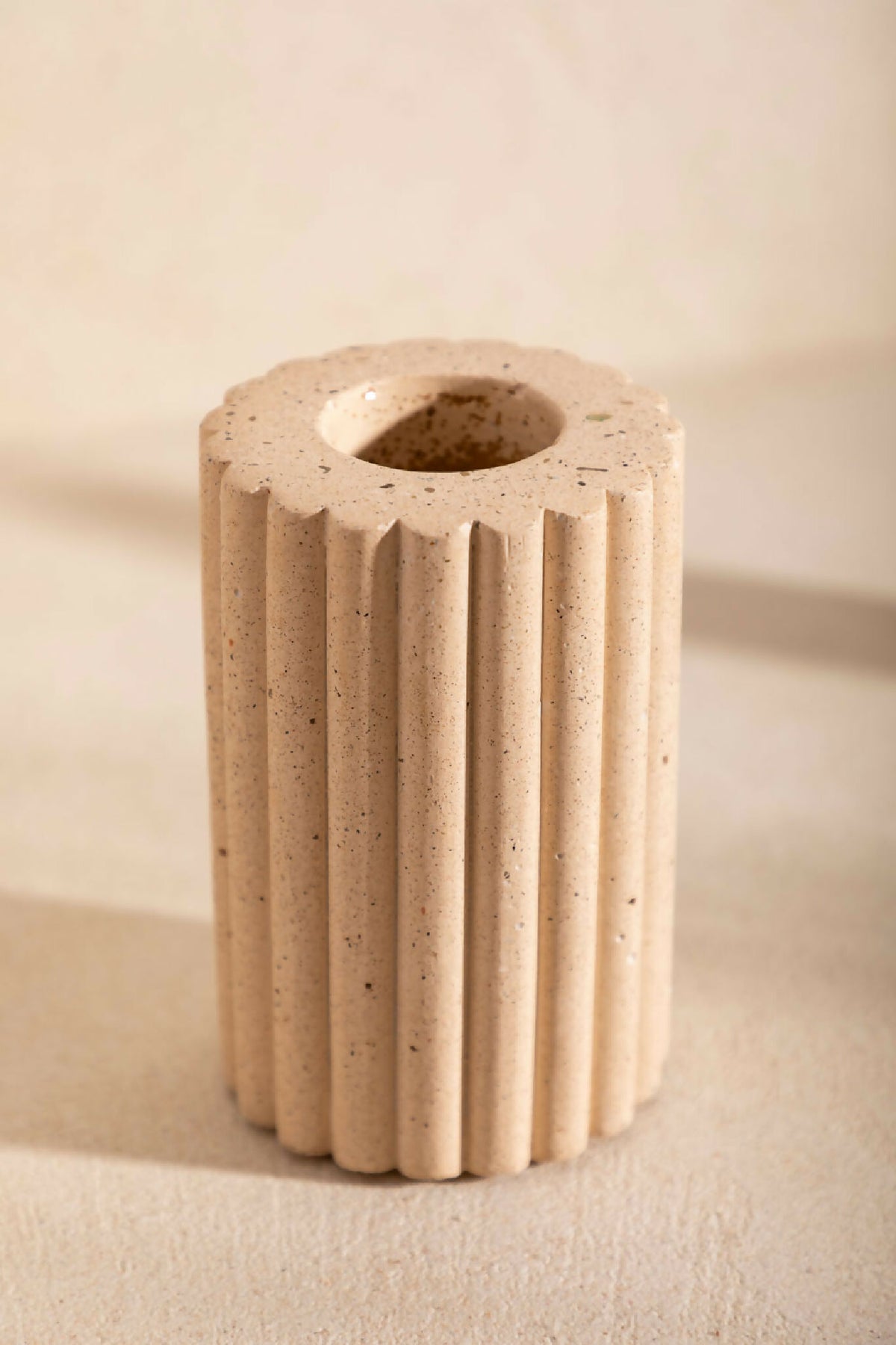 Vase en céramique beige striée, vue du dessus avec ouverture circulaire.
