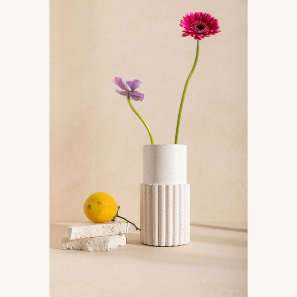 Vase DÉDÉ blanc strié avec fleurs rose vif et violette, tiges vertes.