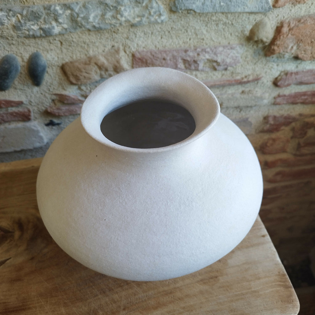 Vase en céramique blanc cassé, ouverture circulaire visible