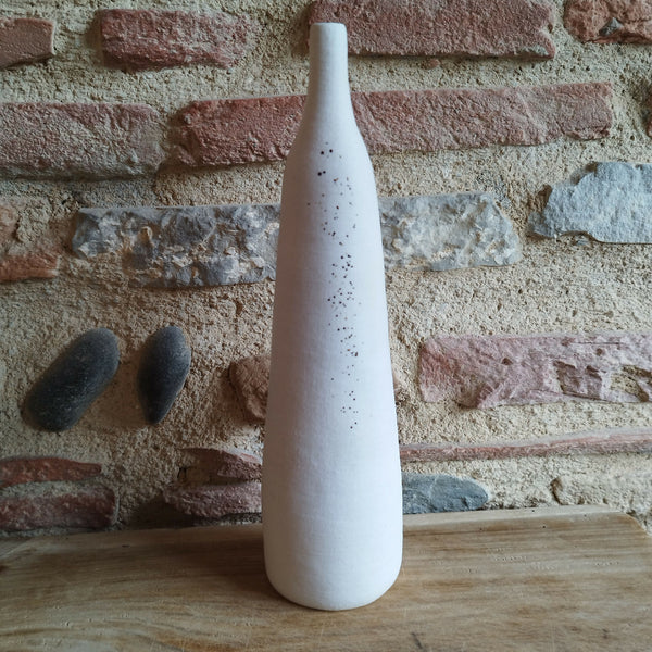 Vase en céramique blanc, haut et fin, décor de points brun-noir et doré.