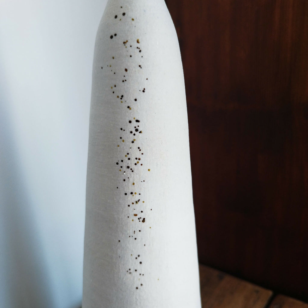 Vase en céramique blanc, motif vertical de points brun et doré.