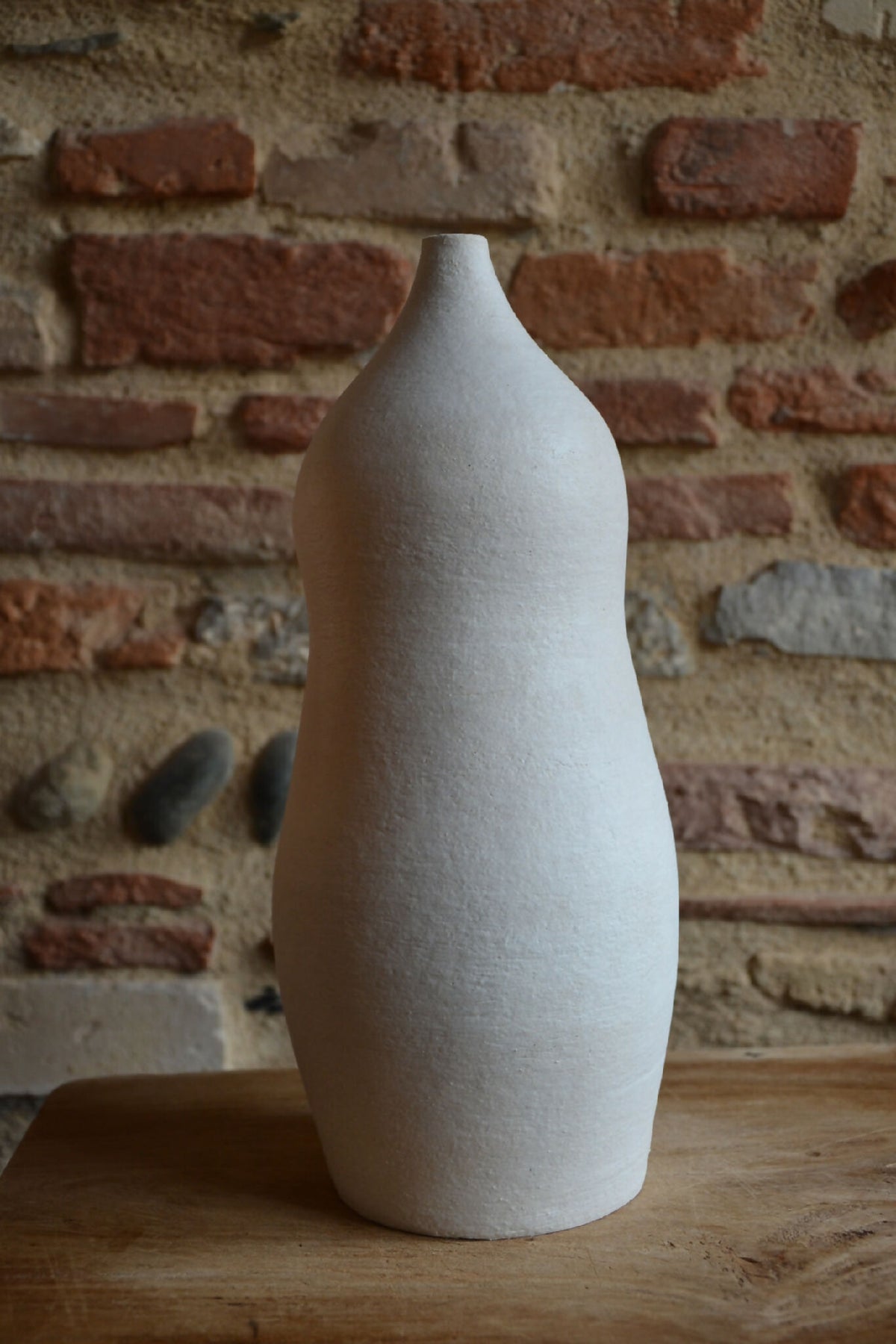 Vase en céramique blanc cassé, silhouette évasée, surface texturée