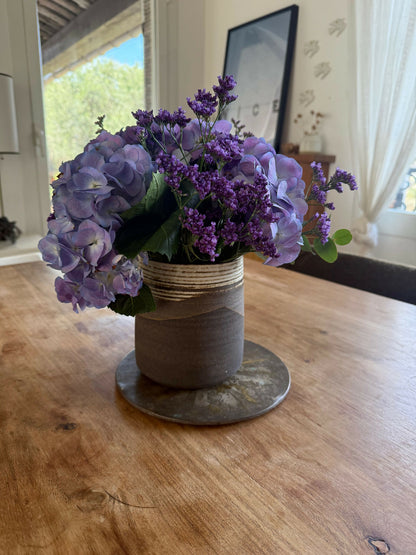 Vase en céramique sombre avec rayures dorées, bouquet de fleurs violettes