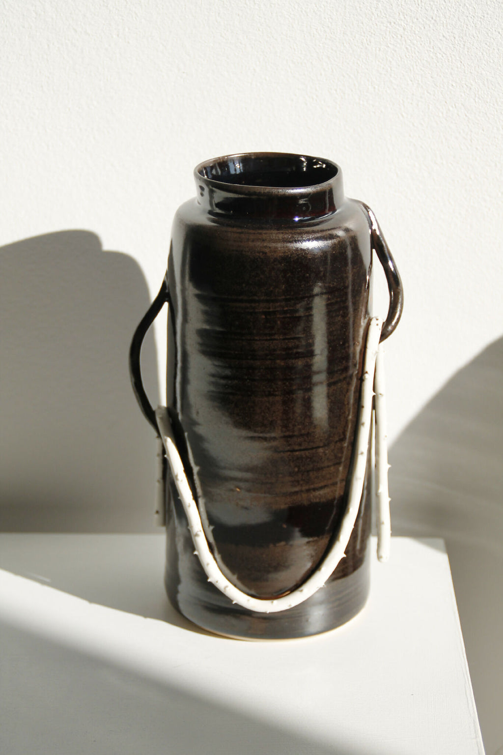 Vase en céramique brun foncé avec deux anses, ouverture large, brillant