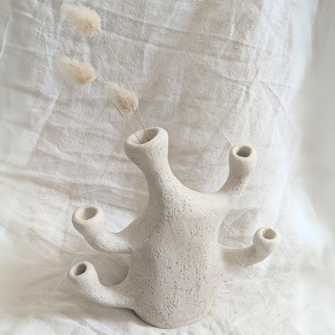 Vase corail beige en céramique avec plusieurs ouvertures, tiges de fleurs et petits plumets