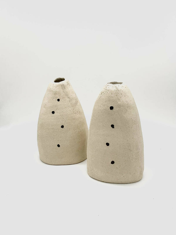 Lot de deux vases coniques DUO en céramique beige, trous noirs sur le devant.