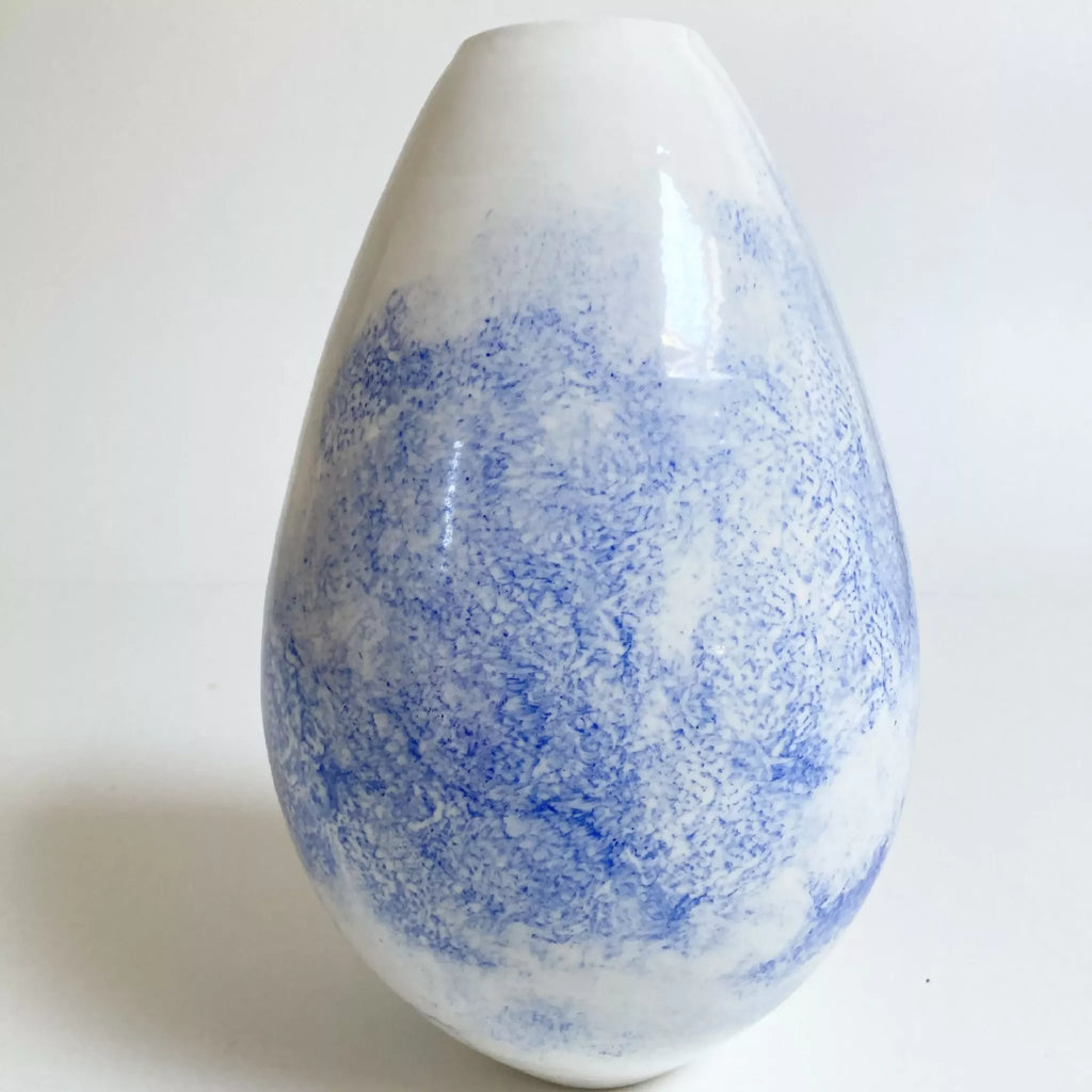 Vase en forme goutte, motifs bleu diffus sur surface blanche brillante.