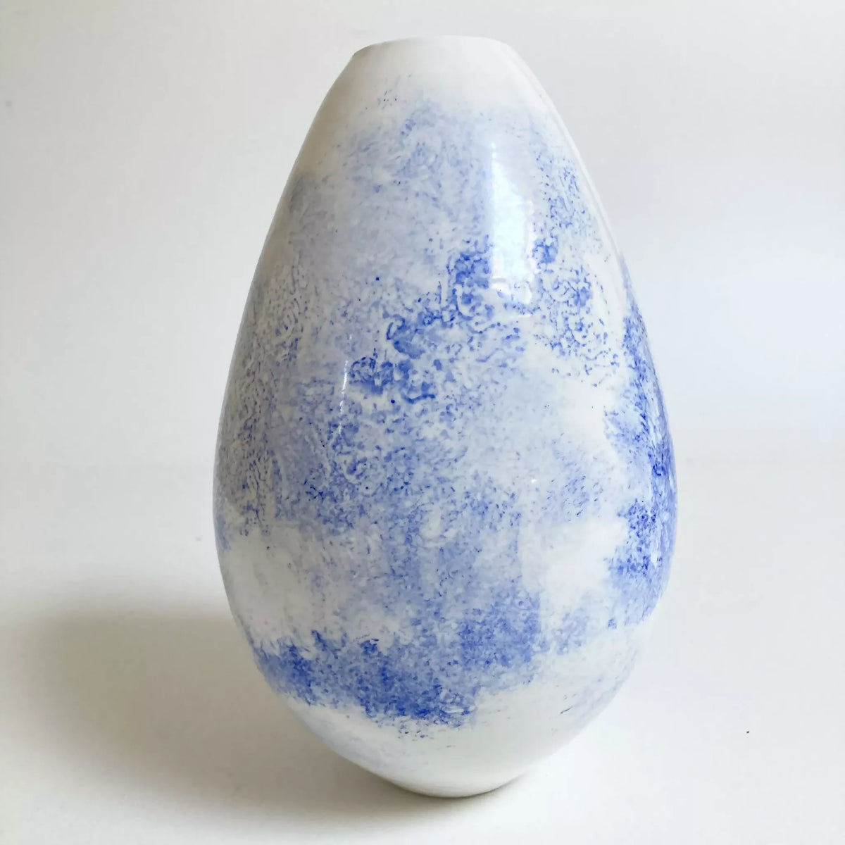 Vase en forme goutte, décor bleu partiellement estompé sur fond blanc.