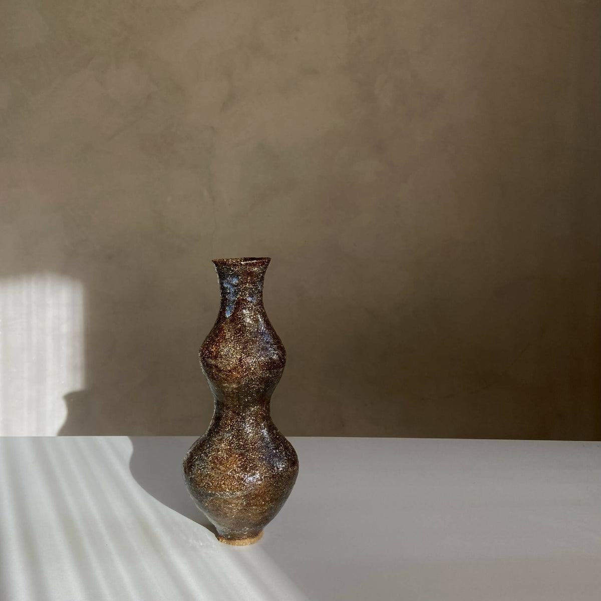 Vase décoratif brun texturé, col étroit et ventre arrondi, forme bulbeuse.
