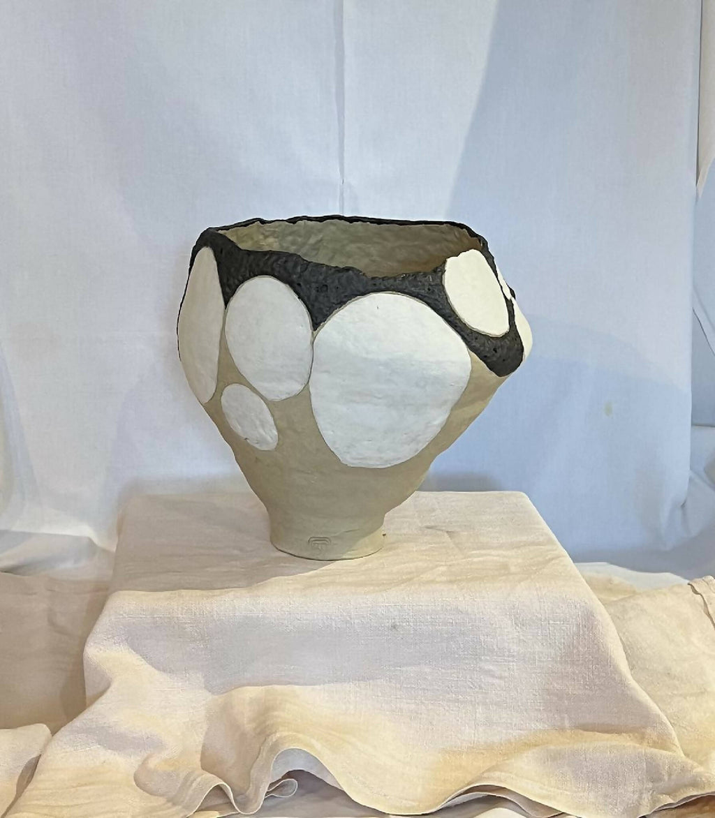 Grand vase beige à ouverture évasée, liseré noir et gros galets blancs