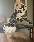 Grand vase beige à motifs galets blancs et bord noir, avec feuillage