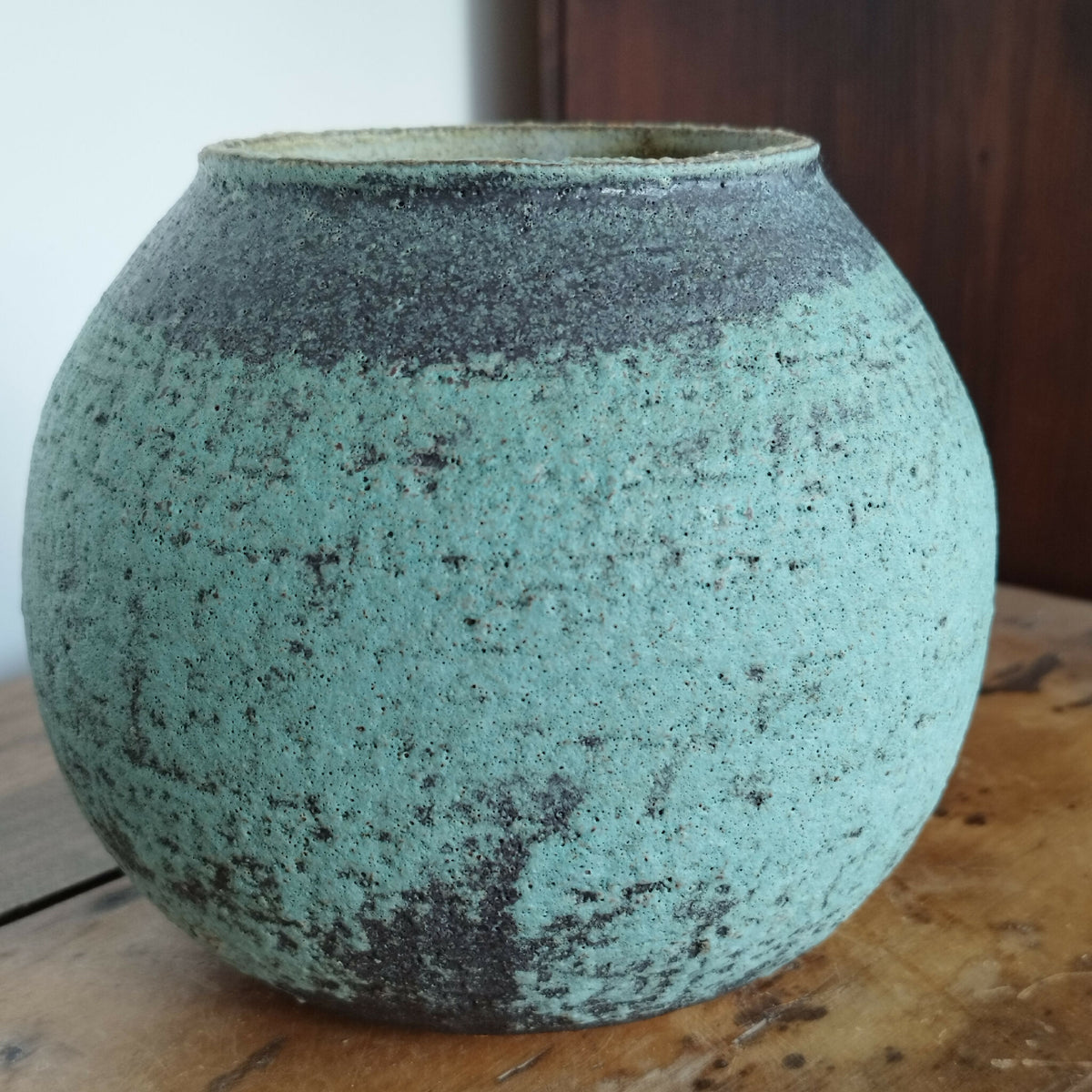 Vase en céramique bleu-vert avec finition granuleuse, vue rapprochée