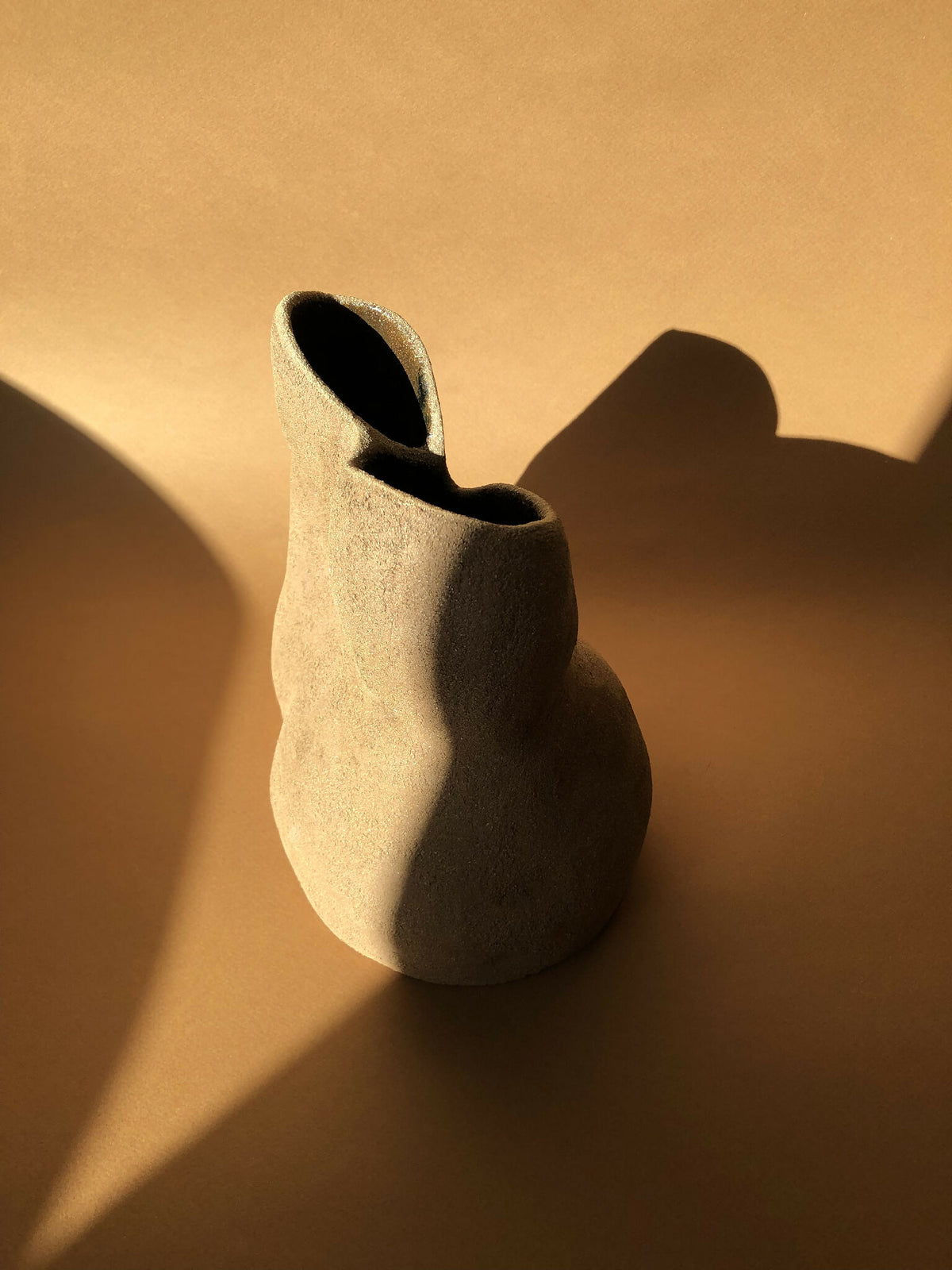 Vase beige au col ouvert, intérieur noir, silhouette arrondie