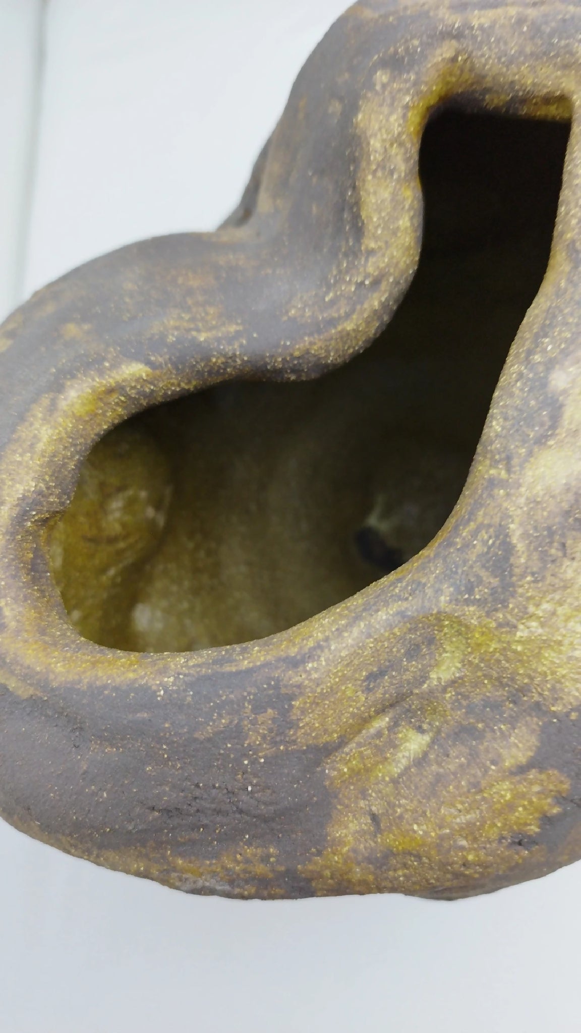 Vase noir et or en forme de goutte, ouverture ovale creusée, intérieur doré.