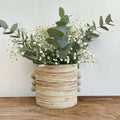 Vase en grès marbré beige cylindrique côtelé, renflements, bouquet de fleurs blanches.
