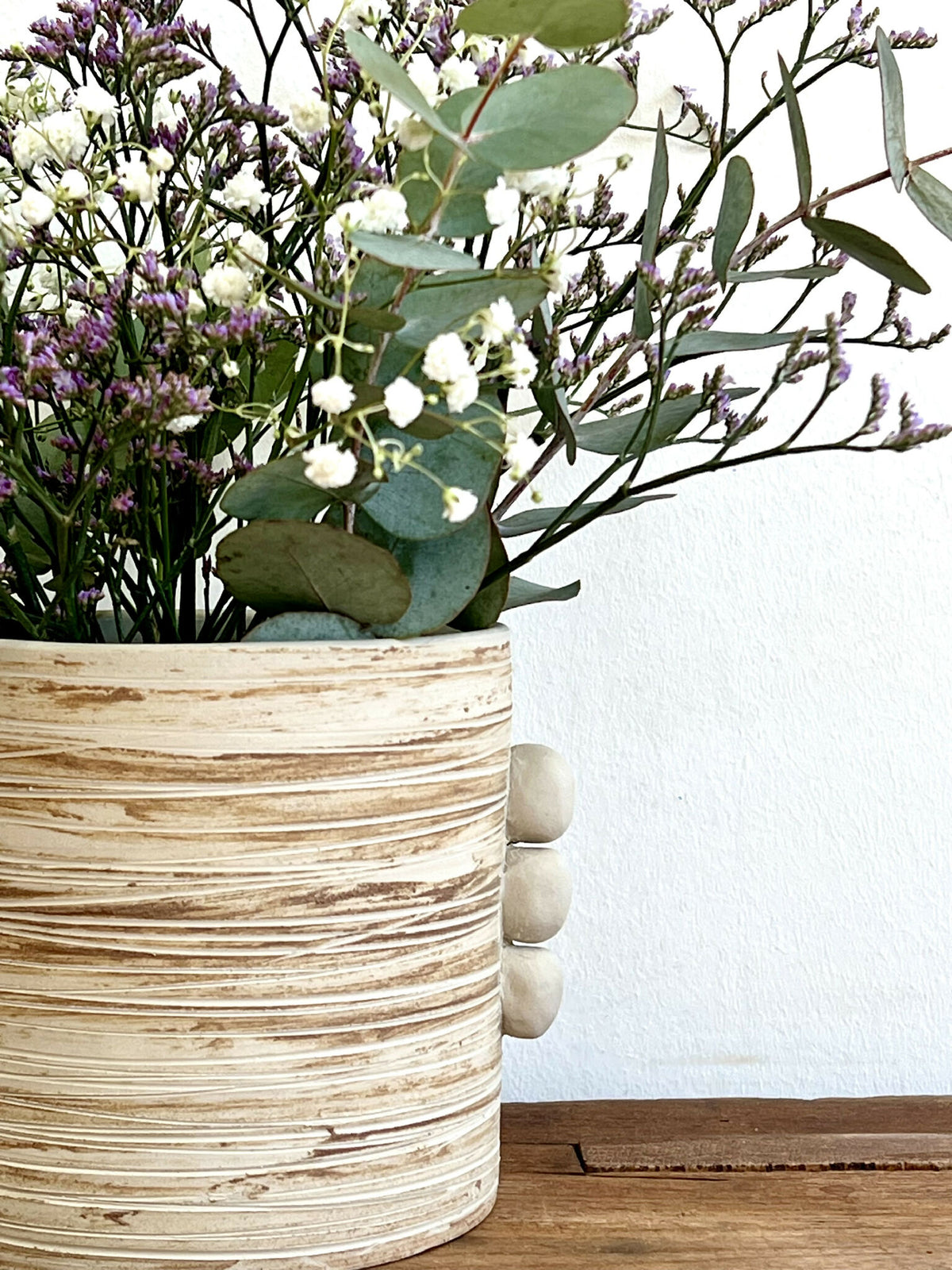 Vase en grès marbré beige, forme cylindrique, décor côtelé et renflements latéraux.