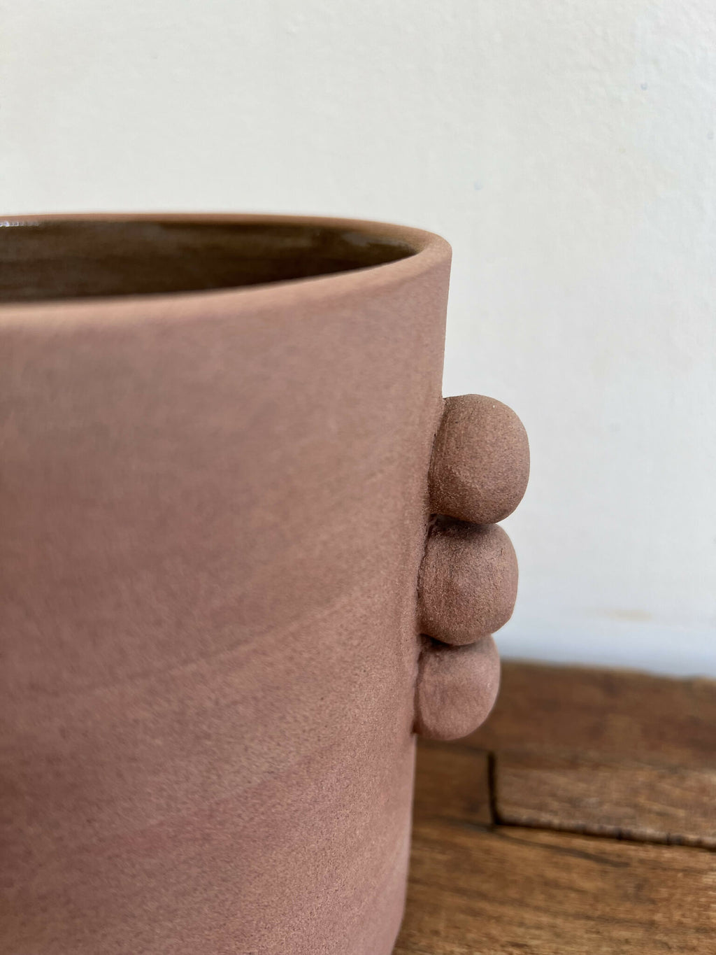 Vase en grès rose terre cuite, gros reliefs arrondis tenant la base, ouverture intérieure.