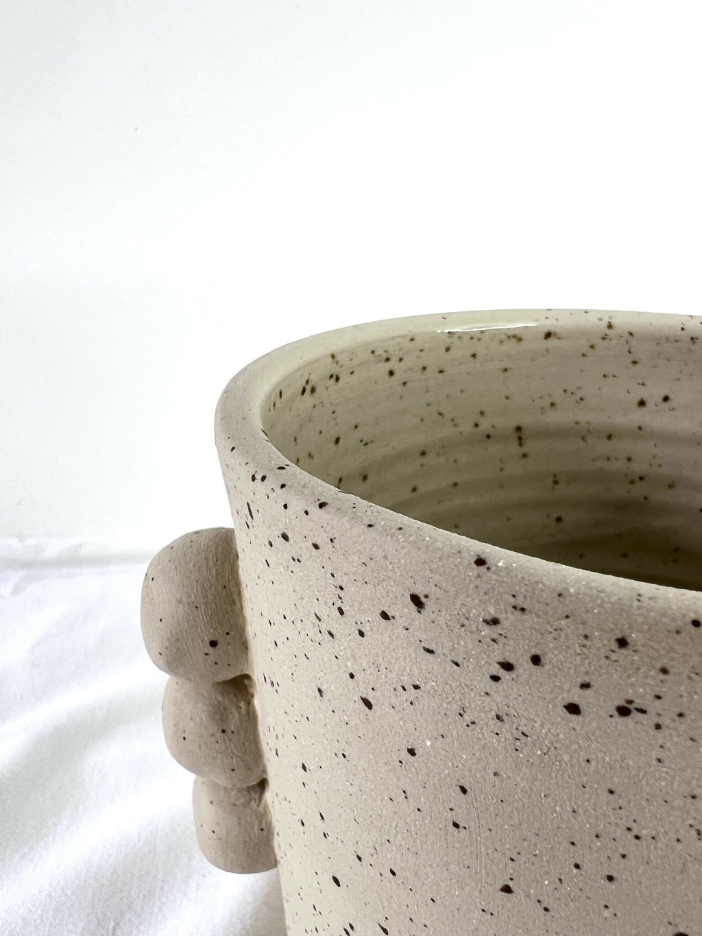 Vase en grès beige specklé, bord évasé, anses rondes en relief sur le côté.